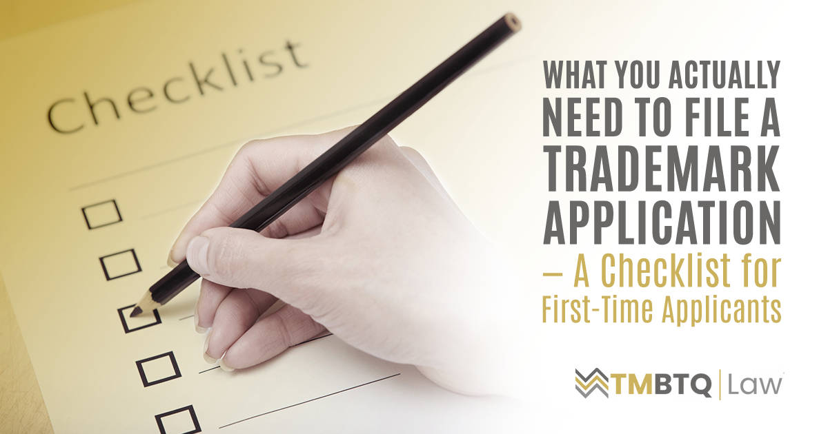 A hand holding a pencil checks a box on a paper checklist labeled 'Checklist,' representing the step-by-step requirements for filing a trademark application.