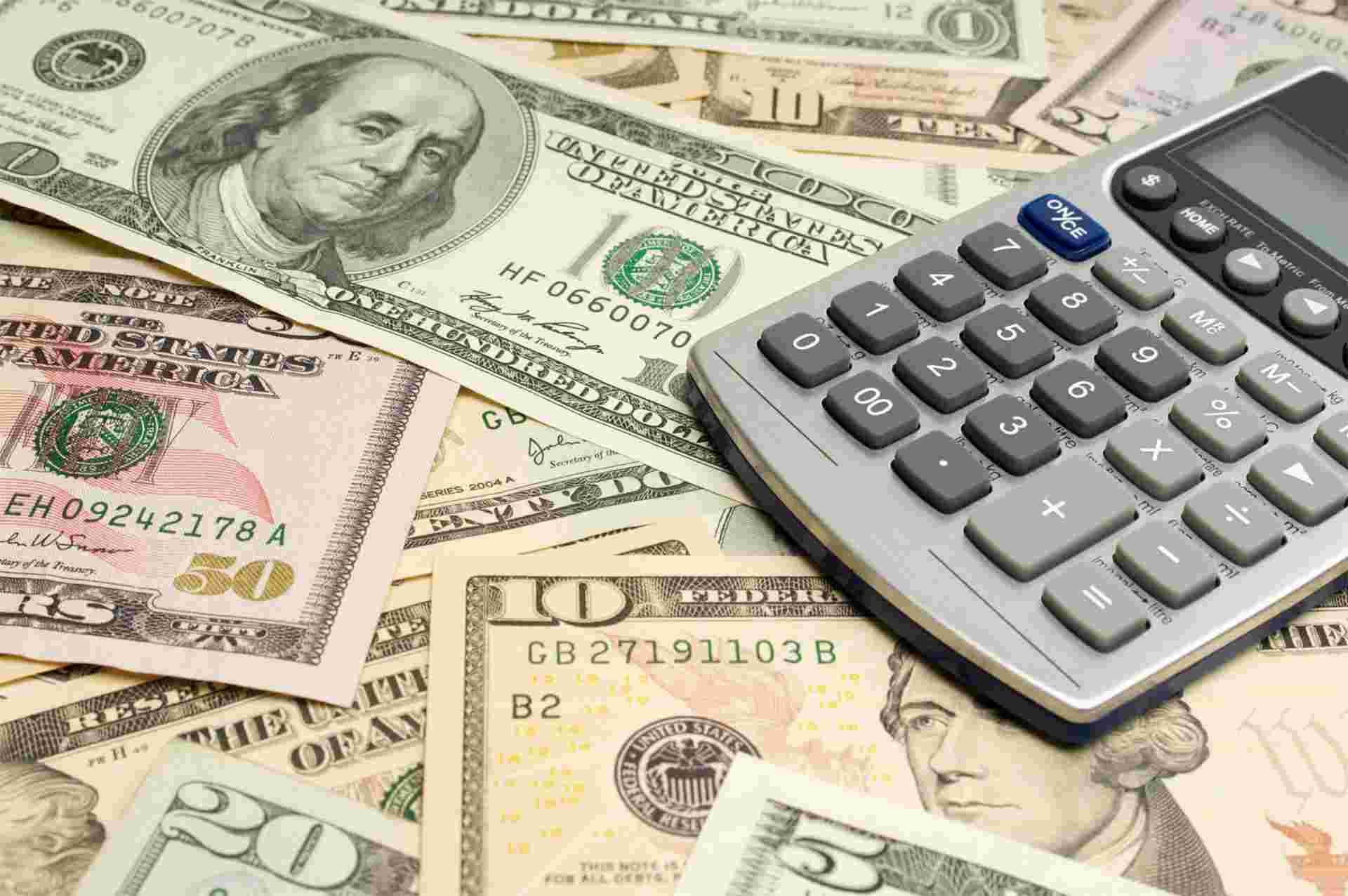 Calculator placed on dollar bills representing TMBTQ Law’s website services related to legal costs, financial planning, and case evaluation.