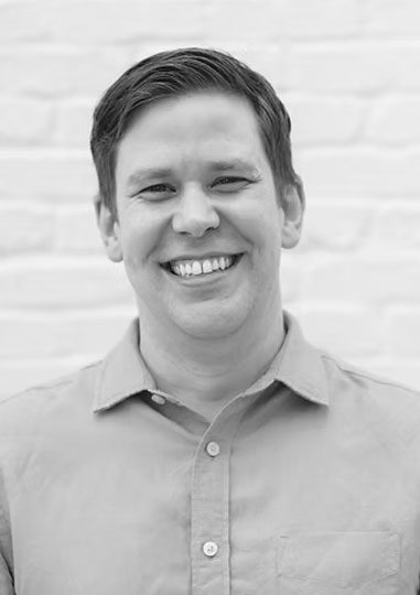 Black-and-white headshot of Chase Neely smiling