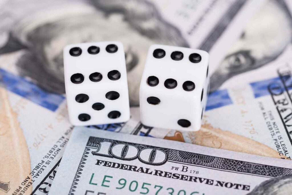 Rolling the dice on wealth Dice on dollar bills, representing TMBTQ Law's website services and expertise in financial legal matters.