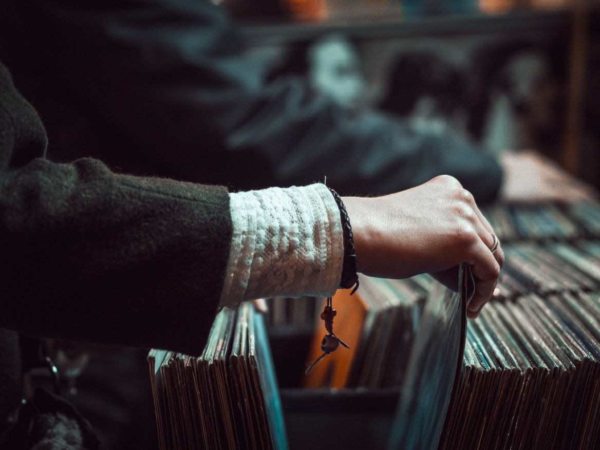 Hand flipping through a row of file folders in dim light