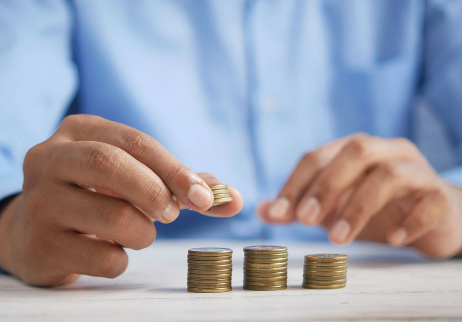 Hand stacking coins into small piles on a table