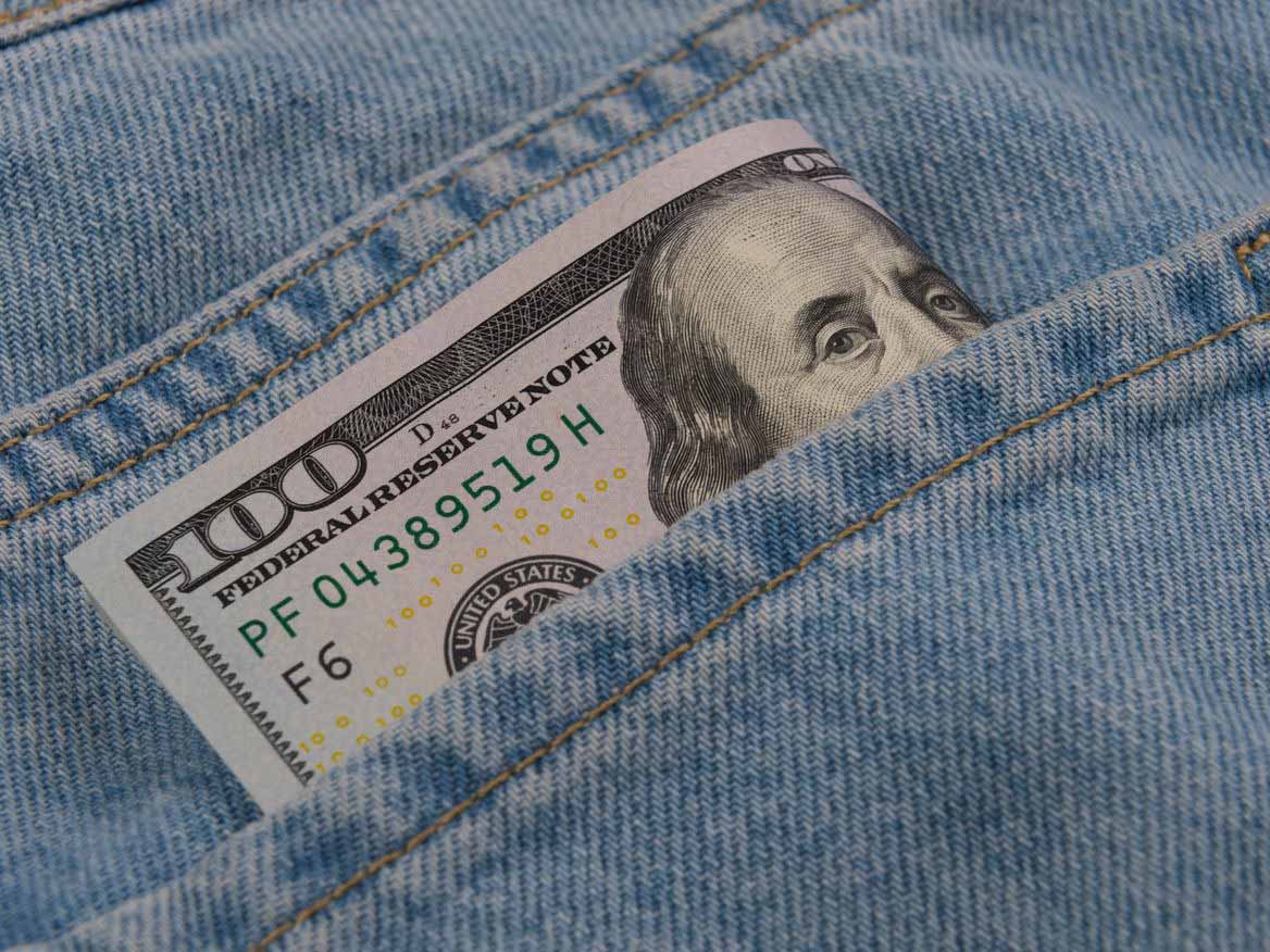 Hundred-dollar bill tucked into a denim jeans pocket