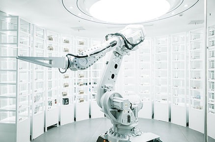 White robotic arm working inside a bright, futuristic white laboratory