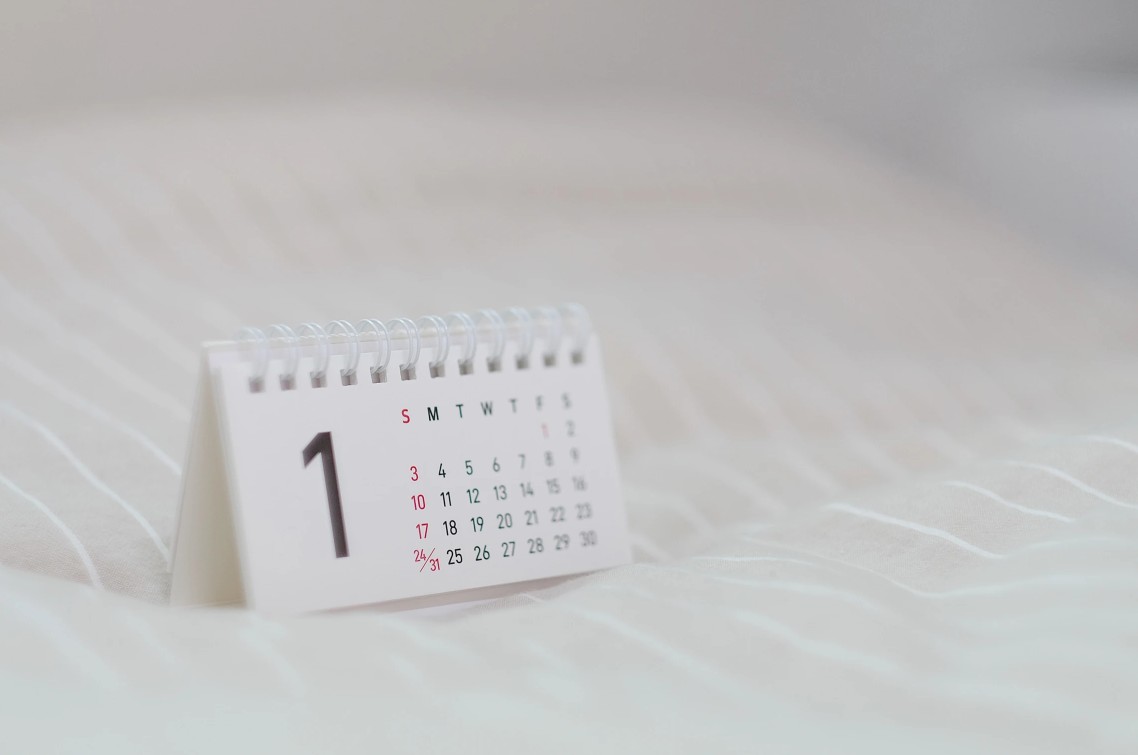 Small white desk calendar standing on soft white fabric