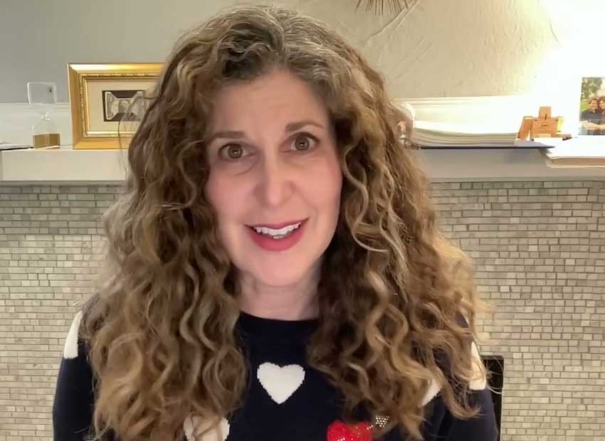 Tamara Pester speaking to the camera in a black sweater with a heart